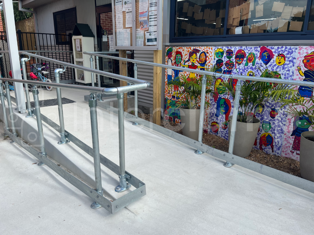 Tube clamp disability compliant handrail, combined with toeboard installed at a school